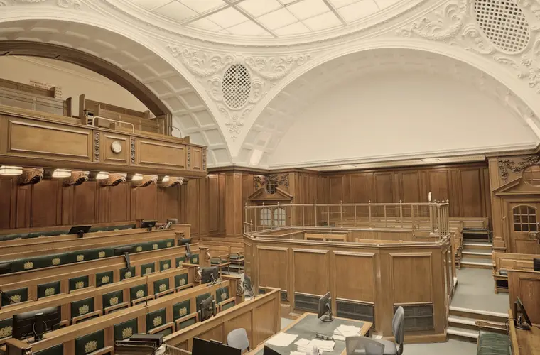 Sala de audiências vazia, com bancos de madeira